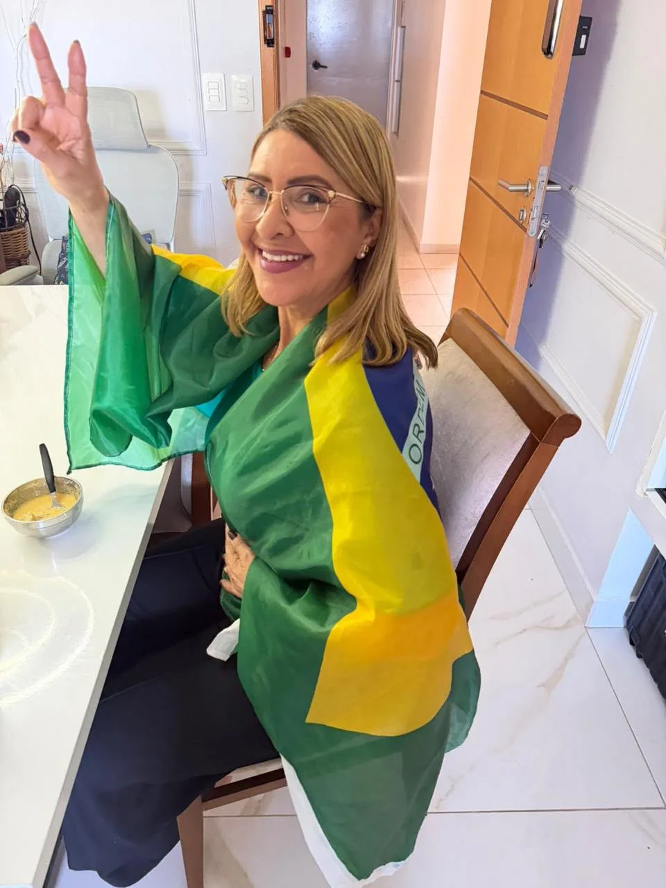 Eleitora enrolada na bandeira do Brasil no domingo do 2º turno
